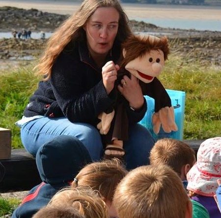Elizabeth with a hand puppet talking to children
