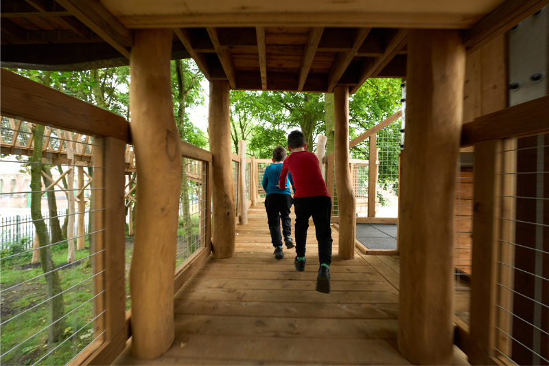 Children playing in wooden play park, waggon woods.